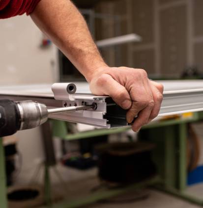 A male with a red shirt making a window with industrial tools