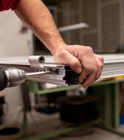 A male with a red shirt making a window with industrial tools